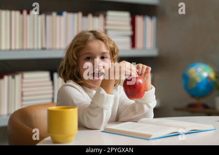 Bildungskonzept. Ein Kind liest ein Buch in einem Buchladen oder einer Schulbibliothek. Stockfoto