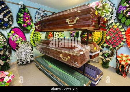 Innenraum des Raumes mit Bestattungszubehör. Geschäft mit Särgen, Beerdigungskränzen und Blumen. Stockfoto