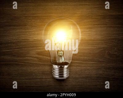 Kreativität mit Lampen, die auf Holzhintergrund glitzern Stockfoto
