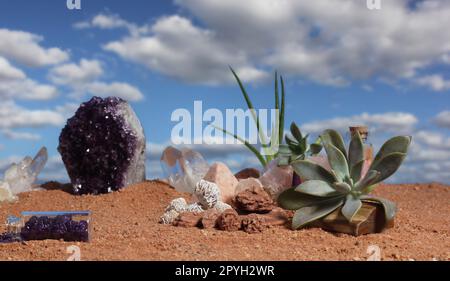 Chakra-Steine und Blumen auf australischem rotem Sand Stockfoto