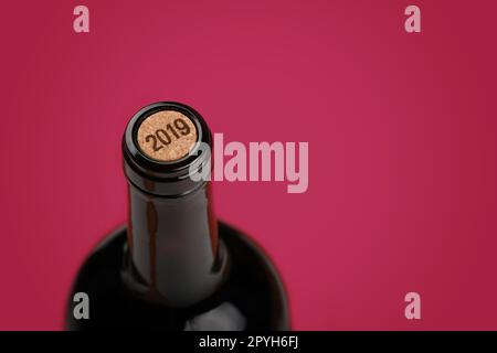 Flasche Rotwein mit Kork auf lila Hintergrund Stockfoto