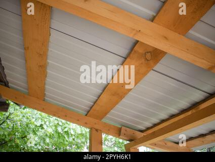 Nahaufnahme von Dachsparren aus Holz mit Wellpappe aus Metall, Ansicht von unten Stockfoto