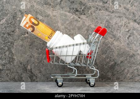 Pillen-Flasche und Euro-Geld in einem Warenkorb Stockfoto