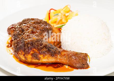 Hähnchen Rendang serviert mit Kokosmilch Reis und eingelegtem Gemüse Stockfoto