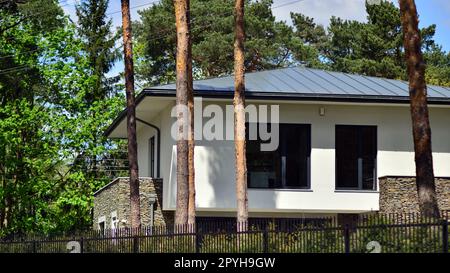 Gehobenes Haus in einem Waldgebiet. Fragment einer Einfamilienhausfassade. Stockfoto