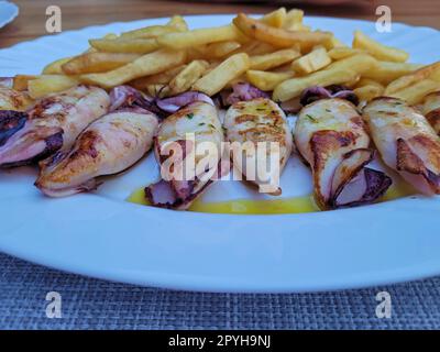 Teller mit gegrillten Kalmaren und Pommes frites Stockfoto