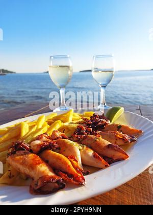 Teller mit gegrillten Kalmaren und Pommes frites Stockfoto