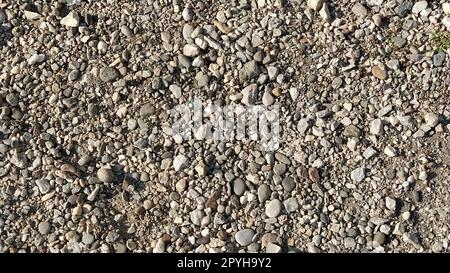 Grauer Steinhintergrund. Graue Steine. Kleiner und großer zerdrückter Stein. Natürlicher Hintergrund. Stockfoto