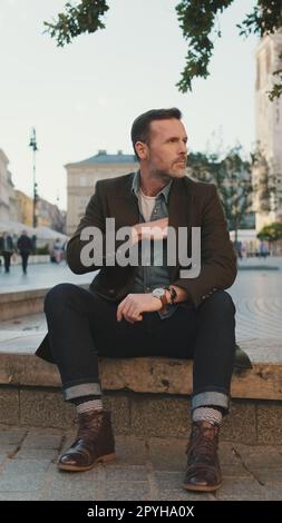 Der Mann sitzt auf dem Platz der Altstadt Stockfoto