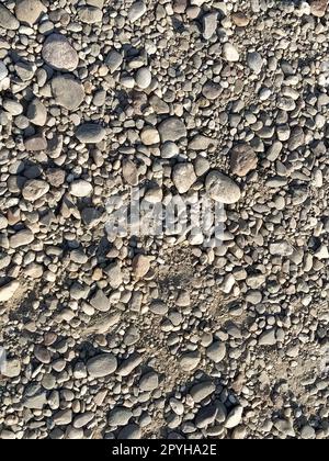 Grauer Steinhintergrund. Graue Steine. Kleiner und großer zerdrückter Stein. Natürlicher Hintergrund. Stockfoto