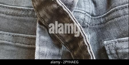 Modische Denimkleidung. Details und Nähte auf rauem Denim. Schwarzweißfotografie Stockfoto