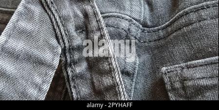 Modische Denimkleidung. Details und Nähte auf rauem Denim. Schwarzweißfotografie Stockfoto