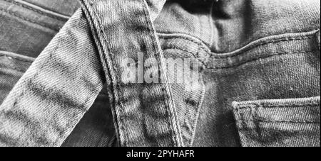 Modische Denimkleidung. Details und Nähte auf rauem Denim. Schwarzweißfotografie Stockfoto