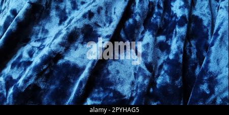 Samtiger Velours-Hintergrund mit leuchtenden Licht- und dunklen Schatten. Hintergrund für Theater- und Modedesigns. Schöner blauer Stoff mit Überlauf. Weichzeichner Stockfoto