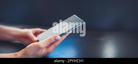 Frau im Haus mit Handy in der Hand. Stockfoto
