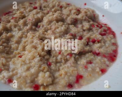 Bio-Müsli mit Hafer, Puderzucker und trockenen Himbeeren. Gesundes Müsli mit Wasser gewürzt. Kalorienarme Diät. Antidiabetika Stockfoto