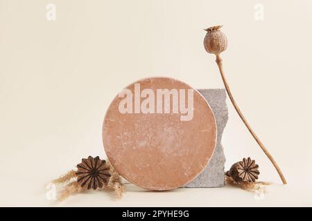 Abstrakte Naturszene aus Steinen, getrockneter Mohnsamen. Neutraler beigefarbener Hintergrund für Kosmetik Stockfoto