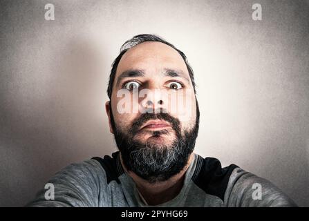 Lustiger Mann mit dem Bart, der Ausdrücke macht Stockfoto