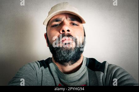 Lustiger Mann mit dem Bart, der Ausdrücke macht Stockfoto