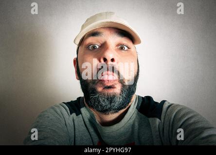 Lustiger Mann mit dem Bart, der Ausdrücke macht Stockfoto