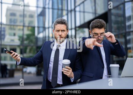 Ausdrucksgesicht eines emotionalen Geschäftsmannes. Ein seriöser Geschäftsmann, der mit dem Finger auf Sie zeigt. Porträt eines Geschäftsmannes im Anzug im Freien. Die Partnerschaft Stockfoto