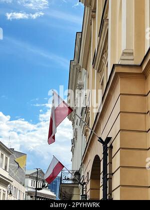 WARSCHAU, POLEN - 17. JULI 2022: Gebäudefassade mit Flaggen an sonnigen Tagen Stockfoto