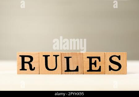 Wortregeln aus Würfeln mit Buchstaben auf einem hellen Holztisch Stockfoto
