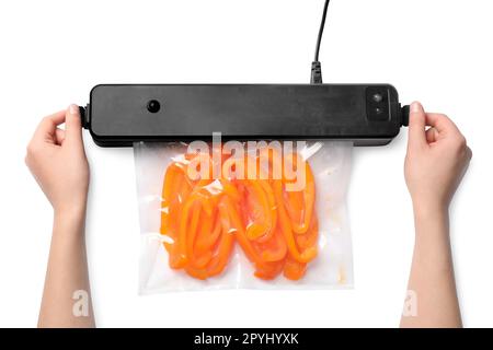 Frau, die Versiegelung für Vakuumverpackungen verwendet, mit Plastikbeutel mit Paprika auf weißem Hintergrund, Draufsicht Stockfoto