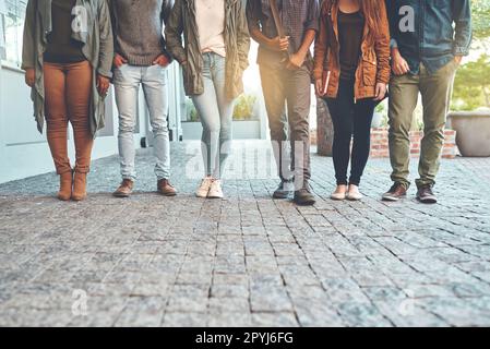 Wir stehen zusammen für Bildung. Eine Gruppe junger Studenten, die im Freien auf dem Campus stehen. Stockfoto