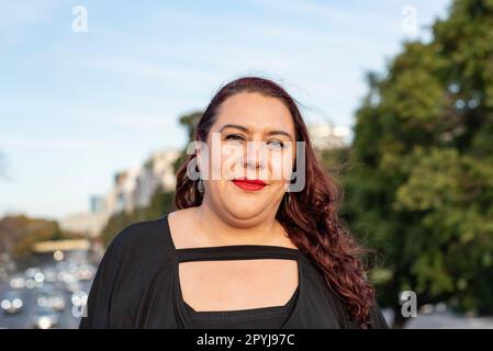 Porträt einer übergroßen Frau, die draußen in die Kamera schaut Stockfoto