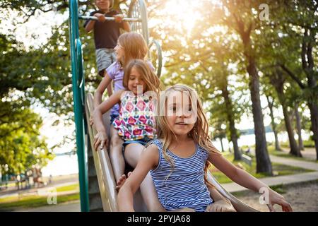 Das Beste an Erinnerungen ist, sie zu machen. Geschwister, die draußen auf einem Spielplatz spielen. Stockfoto