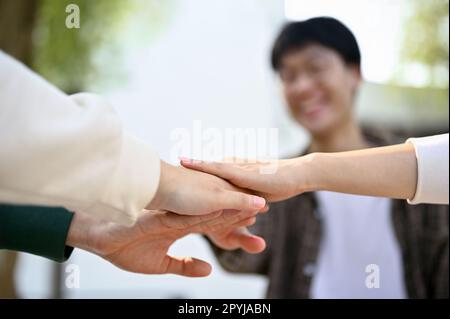 Nahaufnahme verschiedener Studenten, die ihre Hände zusammenlegen, um sich aufzuheitern. Teamarbeit, Freundschaft, Zusammengehörigkeit, Einheit, Beziehung Stockfoto