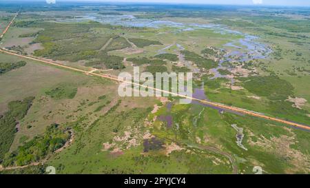 Luftaufnahme von Transpantaneira Schotterstraße durch die typische Pantanal Feuchtlandschaft mit Lagunen, Flüssen, Wiesen und Wäldern, Mato Grosso, Brasilien Stockfoto