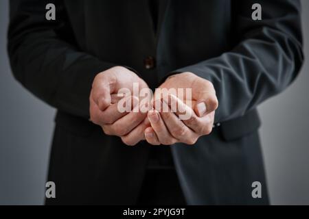 Hilfe, bitte. Beschnittene Studioaufnahme eines Geschäftsmannes mit geöffneten Händen vor grauem Hintergrund. Stockfoto