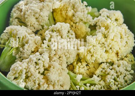 Gekochter Brokkoli in grüner Schüssel auf Holzhintergrund. Schließen. Stockfoto