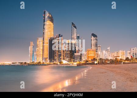Atemberaubender Sandstrand in der Nähe des Ufers von Corniche mit tollem Nachtsicht auf Abu Dhabi, hohe Wolkenkratzer der Vereinigten Arabischen Emirate Stockfoto