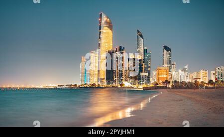 Atemberaubender Sandstrand in der Nähe des Ufers von Corniche mit tollem Nachtsicht auf Abu Dhabi, hohe Wolkenkratzer der Vereinigten Arabischen Emirate Stockfoto