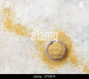 Holzschüssel mit Draufsicht auf trockenen, ungekochten Weizenkörner. Gesundes Essen Stockfoto