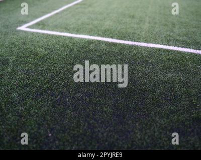 Die Markierung des Fußballfeldes auf dem grünen Gras. Weiße Linien mit einer Breite von maximal 12 cm oder 5 Zoll. Fußballfeld. Stockfoto