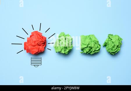 Das Konzept der Inspiration mit neuen Ideen, die Suche nach kreativen Lösungen, zerknitterte Papierbögen in Form von Kugeln auf blauem Hintergrund Stockfoto