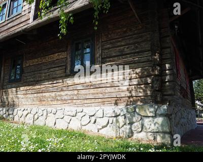 Stanisici, Bijelina, Bosnien und Herzegowina, 25. April 2021. Holzfällerhaus. Traditionelles Wohnhaus im bosnischen Gebirge aus dem 19. Jahrhundert. Restauriertes Ethno-Gebäude, landwirtschaftliche Arbeitsgeräte. Stockfoto