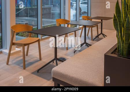 Sitzgelegenheiten im Foyer eines modernen Büros. Moderner minimalistischer Schreibtisch oder Arbeitstisch mit offenem Raum zum Arbeiten mit Fenster. Konferenztische und Bürostuhl Stockfoto
