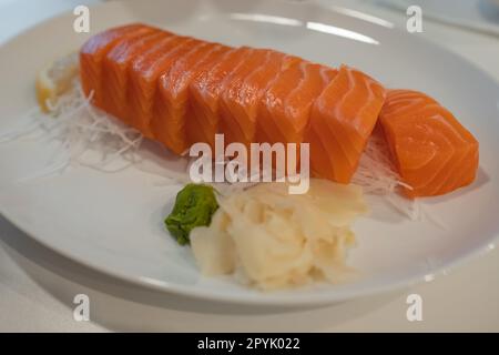 Lachs-Sashimi-Fisch, japanische Küche. Roher Sashimi mit Lachs auf weißem Teller. Berühmtes japanisches Lachs-Omega-3-Gericht. Rohes Lachs-Stück in japanischem Stil, frisch Stockfoto