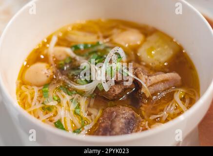 Hausgemachte Rindergemüsesuppe in einer weißen Schüssel. Köstliche Nudelsuppe in einer Schüssel mit Brot. Fleischsuppe mit Gemüse. Gesundes, warmes und komfortables Essen. T Stockfoto