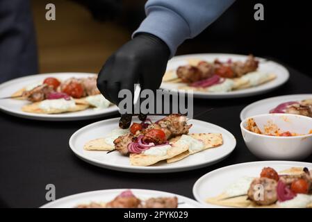 Der Küchenchef im Restaurant bereitet Souvlaki mit Pita und Tzatziki-Sauce zu Stockfoto