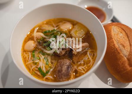 Hausgemachte Rindergemüsesuppe in einer weißen Schüssel. Köstliche Nudelsuppe in einer Schüssel mit Brot. Fleischsuppe mit Gemüse. Gesundes, warmes und komfortables Essen. T Stockfoto