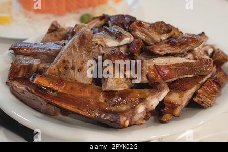 Gegrillte Rippchen auf einem Teller. Speisekarte des Restaurants, Diät. Warme Fleischgerichte geröstete Lammkoteletts Rippchen. Scharfe gegrillte Ersatzrippchen auf dem Teller. Selektiver Fokus, nobo Stockfoto