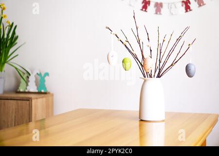 Osterdekoration mit einem Strauß aus Weidenzweigen mit farbigen Eiern. Frohe Ostern. Stockfoto