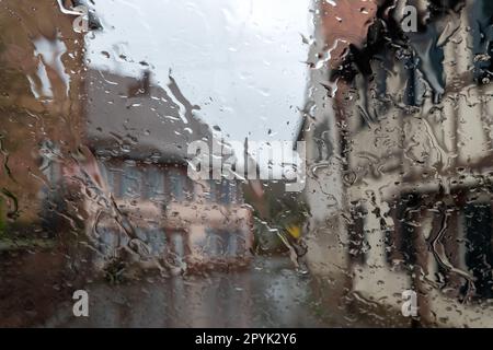 Regentropfen auf dem Glas, verschwommener Hintergrund. Im Freien Stockfoto