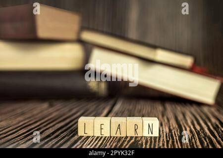 Ein Stapel Bücher, lesen. Stapel Bücher in der farbigen Hülle lagen auf dem Tisch. Offenes Buch mit dem Text Lernen Sie hölzernen Hintergrund, Bildung, Lesen, Lernkonzept Stockfoto